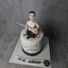 Bağlama çalan erkek figürü ve nota desenleriyle süslenmiş beyaz pasta
