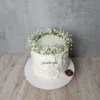 Beyaz çiçeklerden çelenkle süslenmiş beyaz pasta