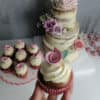 Çiçekli rustik pasta önünde pembe gül süslemeli cupcake