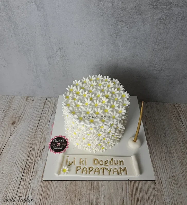 Beyaz ve sarı papatyalarla kaplı doğum günü pastası