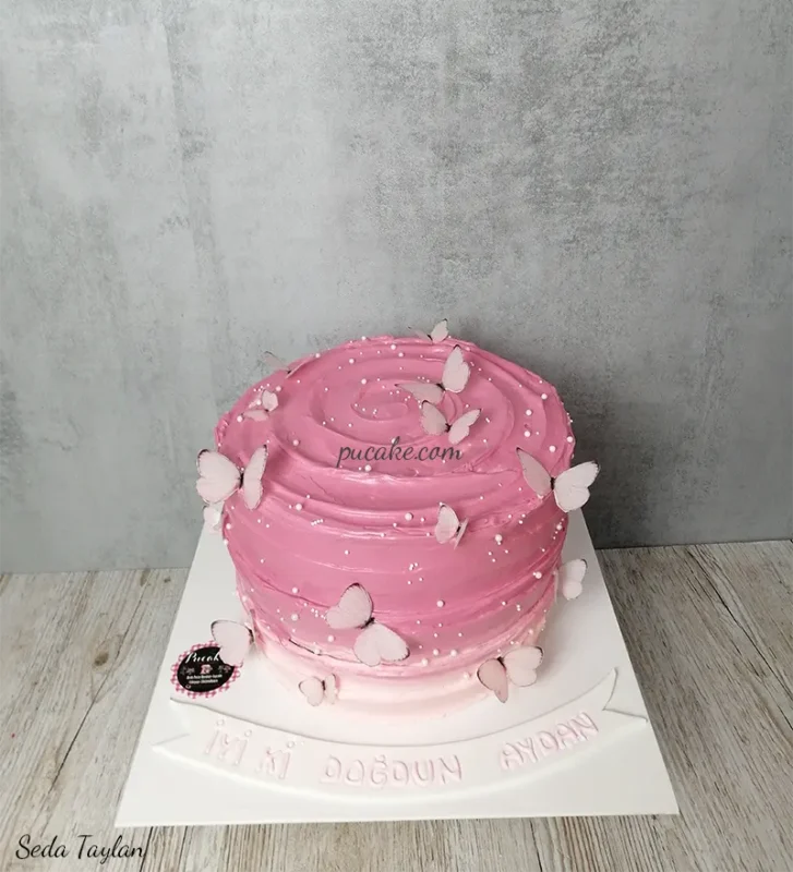 Beyaz kalpler ve krema süslemeleriyle pembe pasta