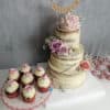 Pembe ve mor çiçeklerle süslenmiş rustik pasta ve cupcakeler