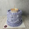 Altın renkli taç ve inci süslemeleri bulunan mor pasta